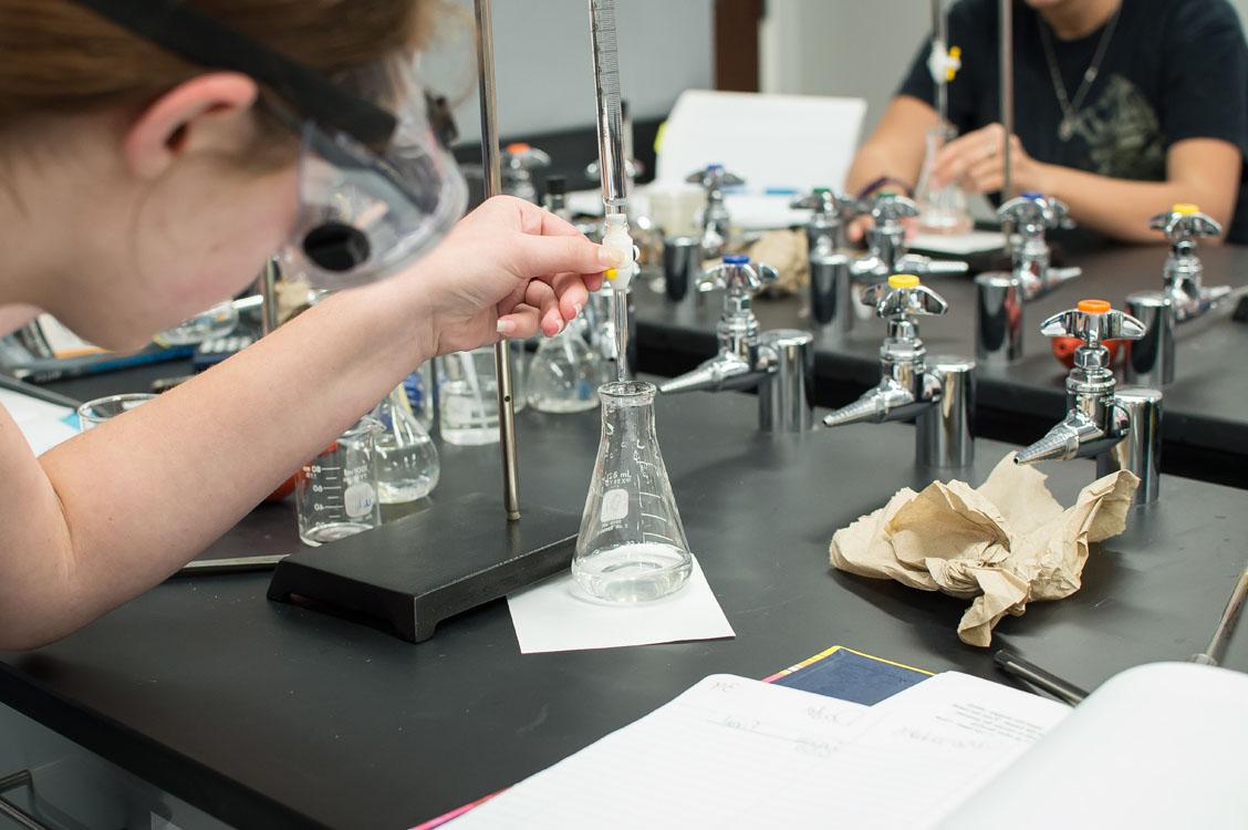 A chemistry student filling a flask with water